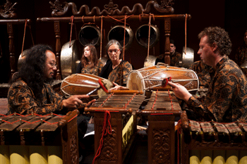 inmitten der bronzenen Kenongkessel sitzen Gamelanmusikser und der Geiger Martin Ehrhardt